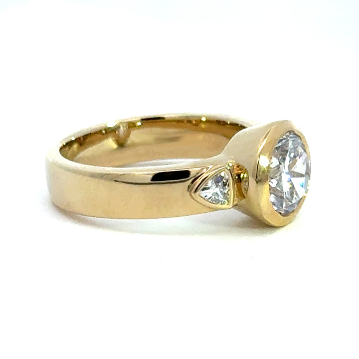 2.2 ctw round diamond bezel three-stone trillion wide band engagement ring