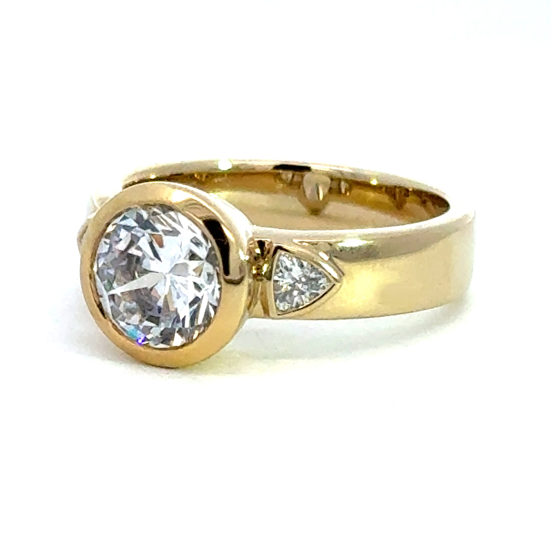 2.2 ctw round diamond bezel three-stone trillion wide band engagement ring