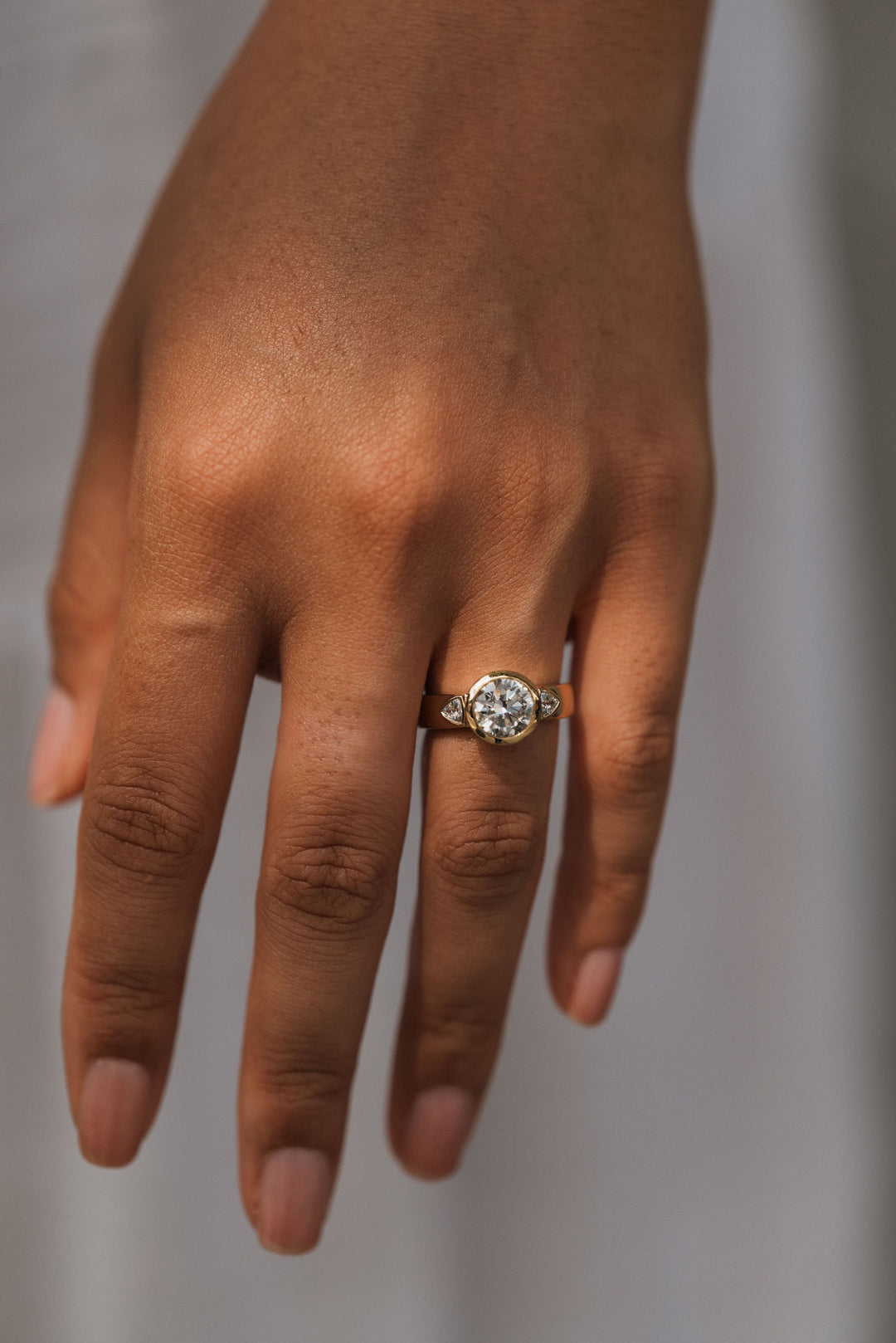 2.2 ctw round diamond bezel three-stone trillion wide band engagement ring